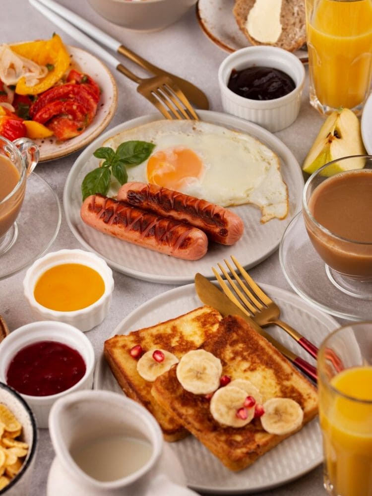 café da manha farto com geleias , pães e ovos.