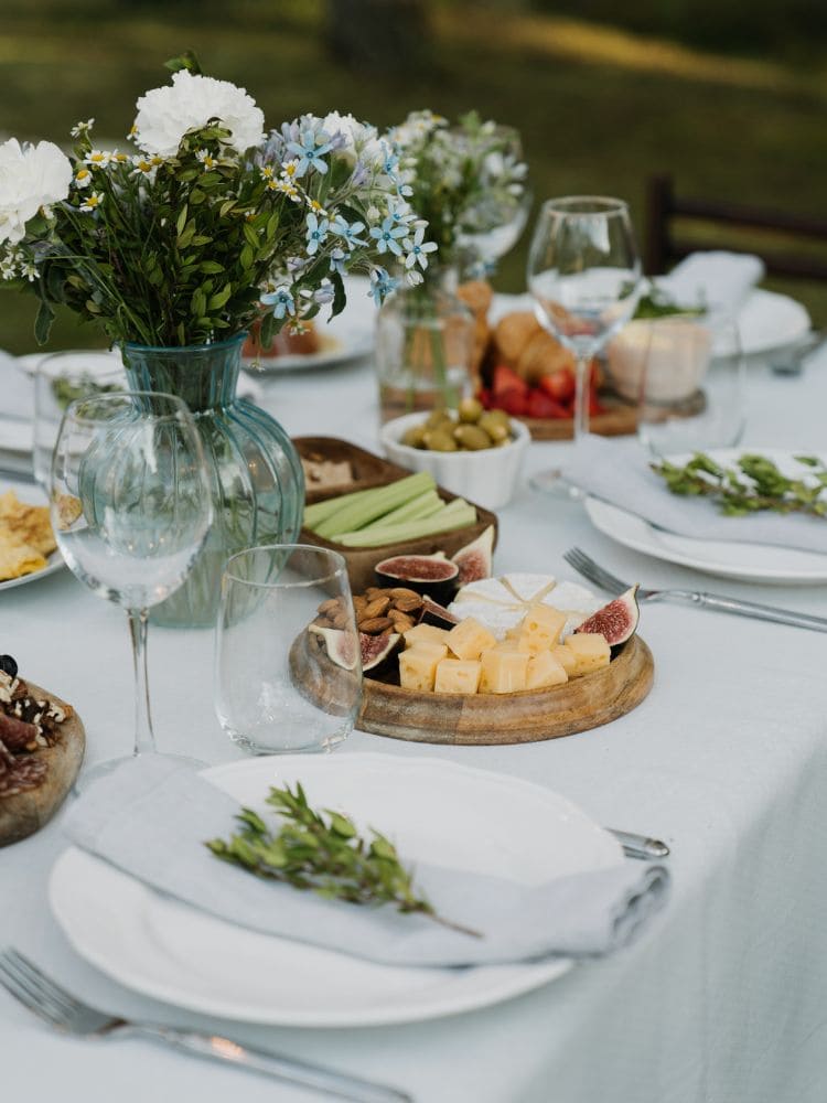 Mesa posta simples branco com petiscos , taças e flores na mesa